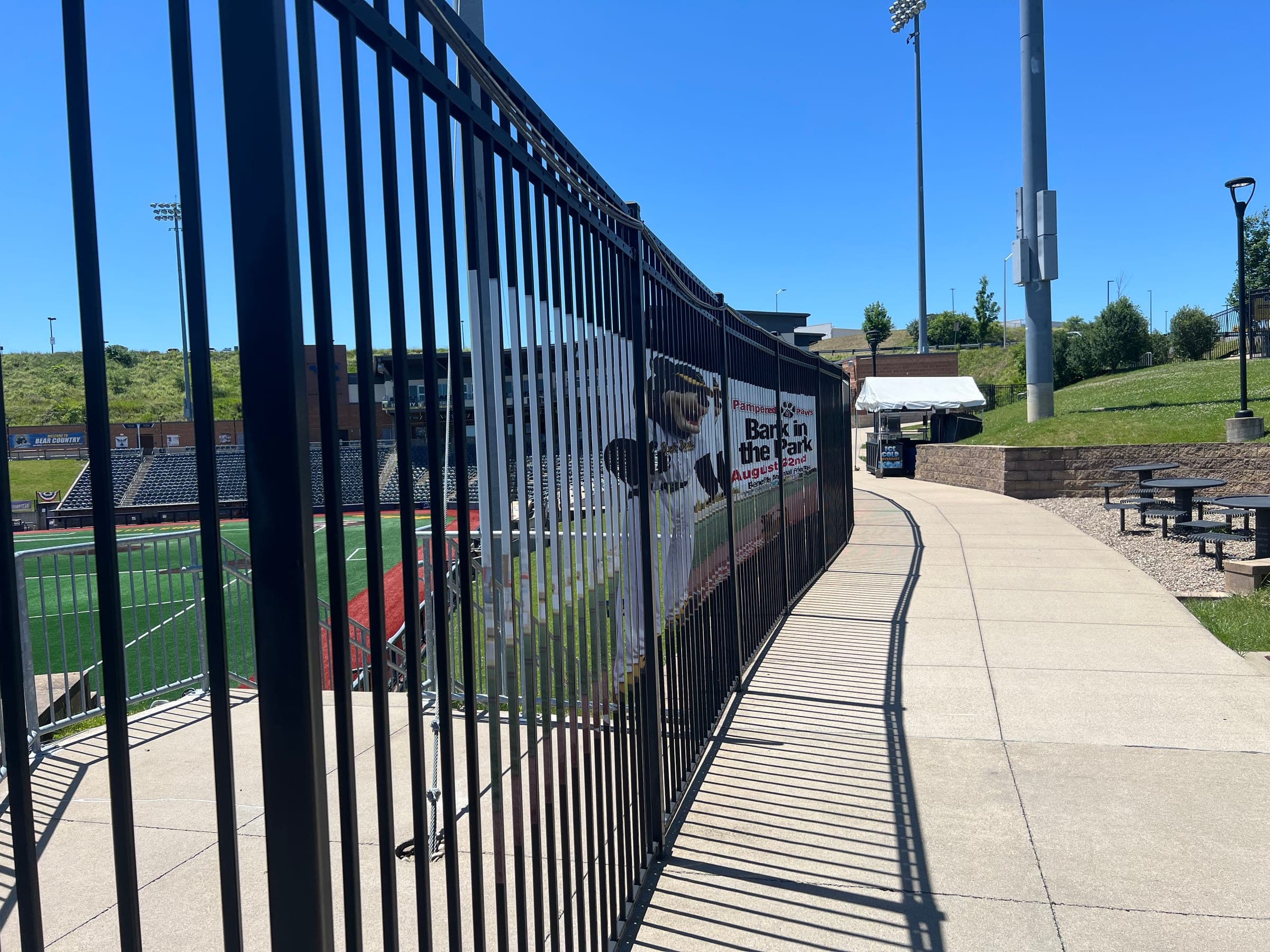 Printed Bark in the Park banner wrapped along a ballpark fence
